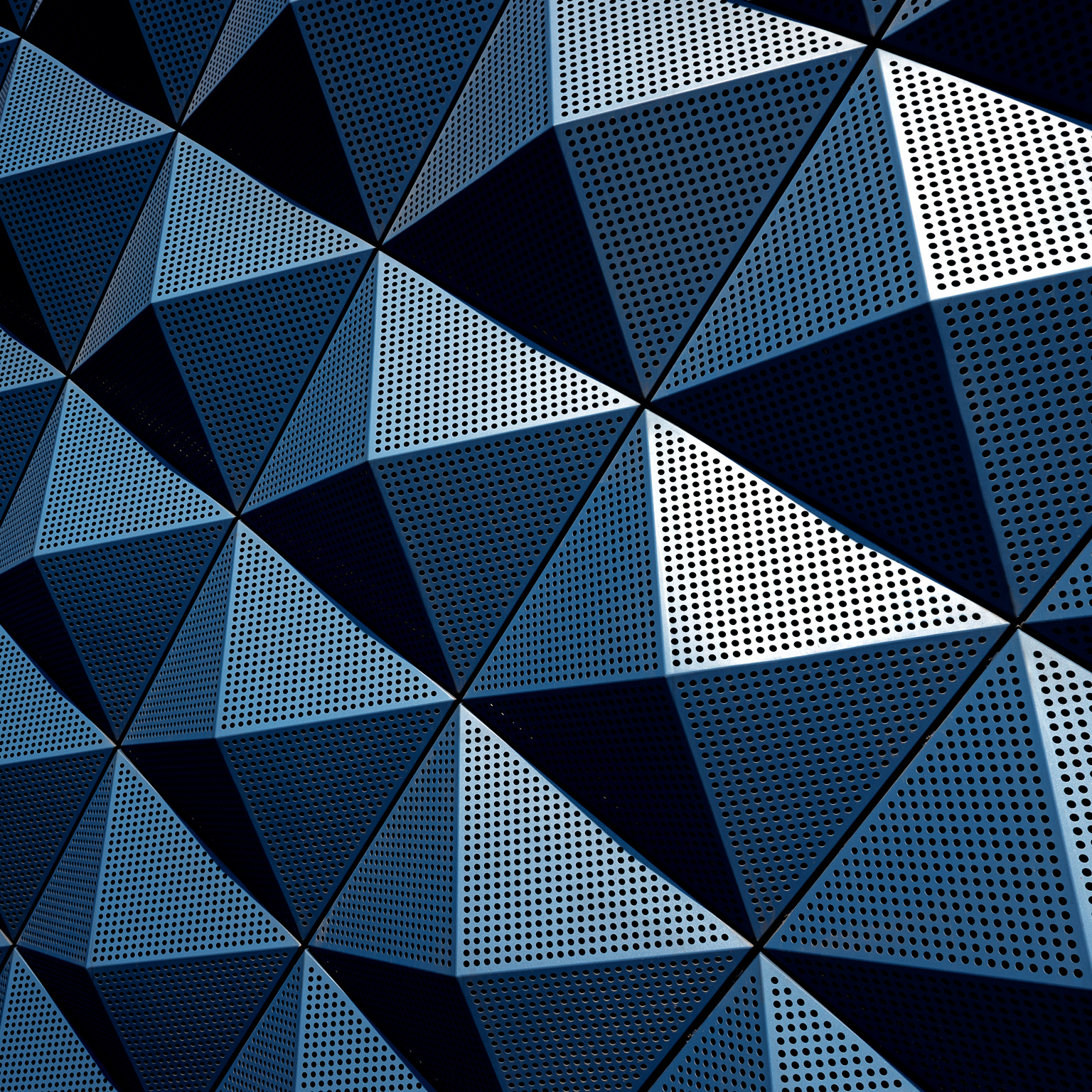 A wall composed of repeating metal triangular pyramids.