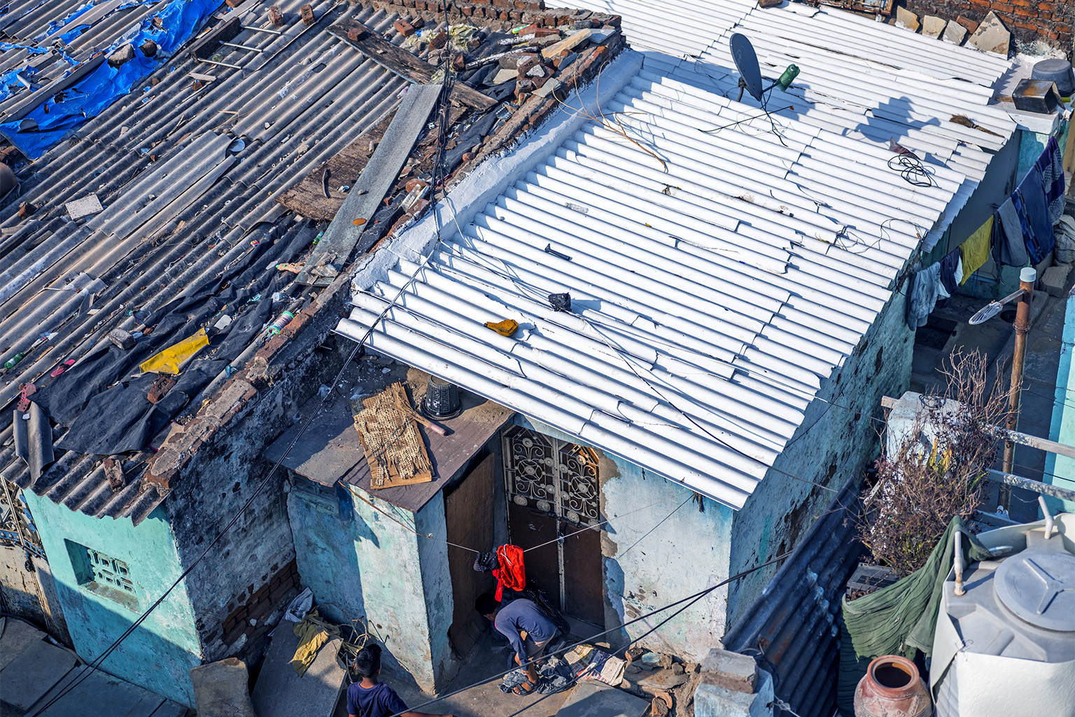Photograph of the roof of a house in India being painted white.