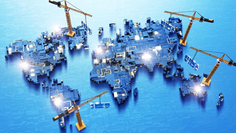 A conceptual illustration of a world map built from interconnected circuit-board components, with several orange construction cranes appearing to assemble different regions. The image is accented by glowing circuitry and blue color palette.