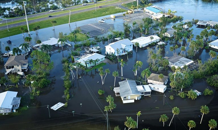 An aerial perspective of a heavily flooded Florida neighborhood next to a river after Hurricane Ian.